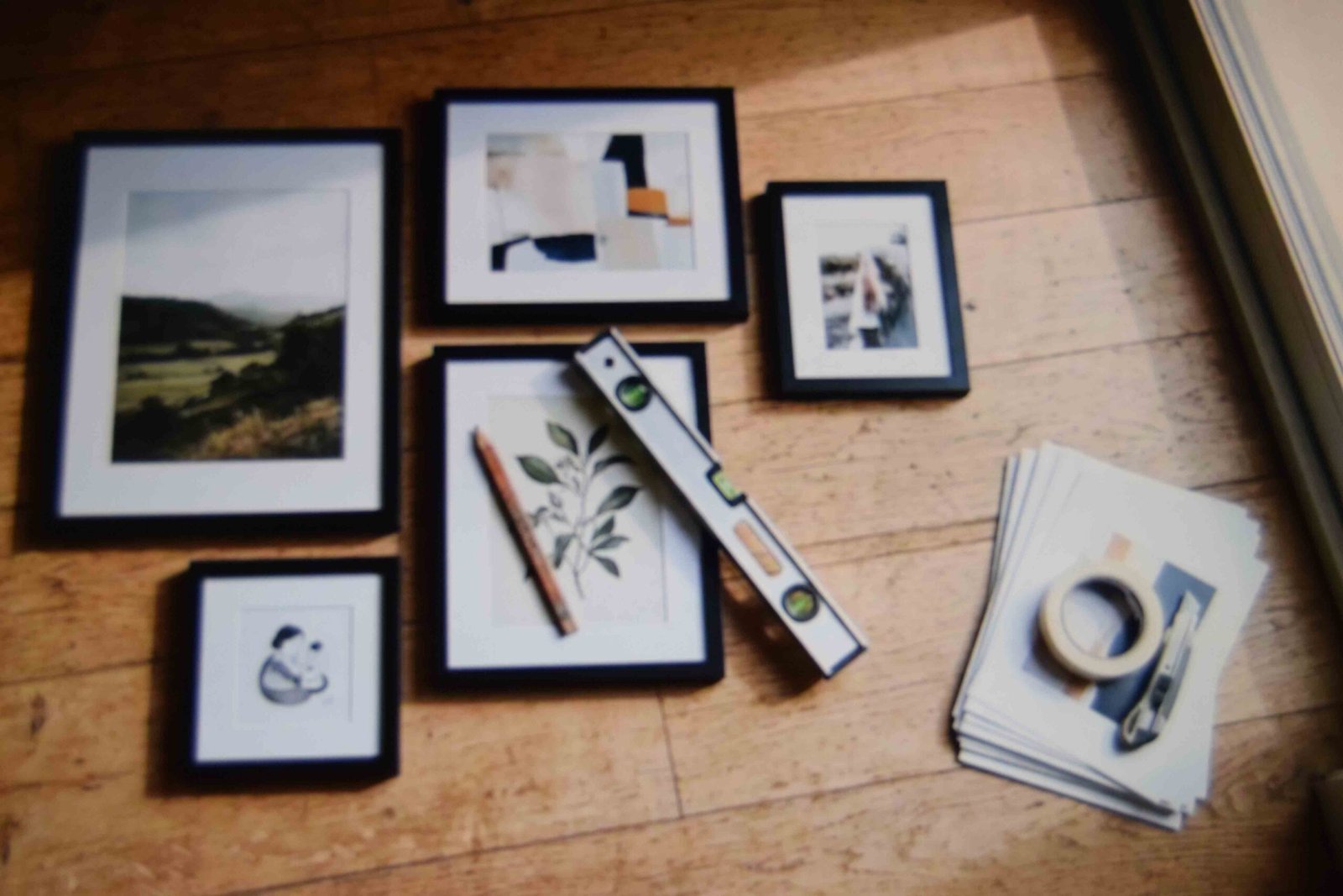 Budget frames and loose prints laid out on the floor before going up