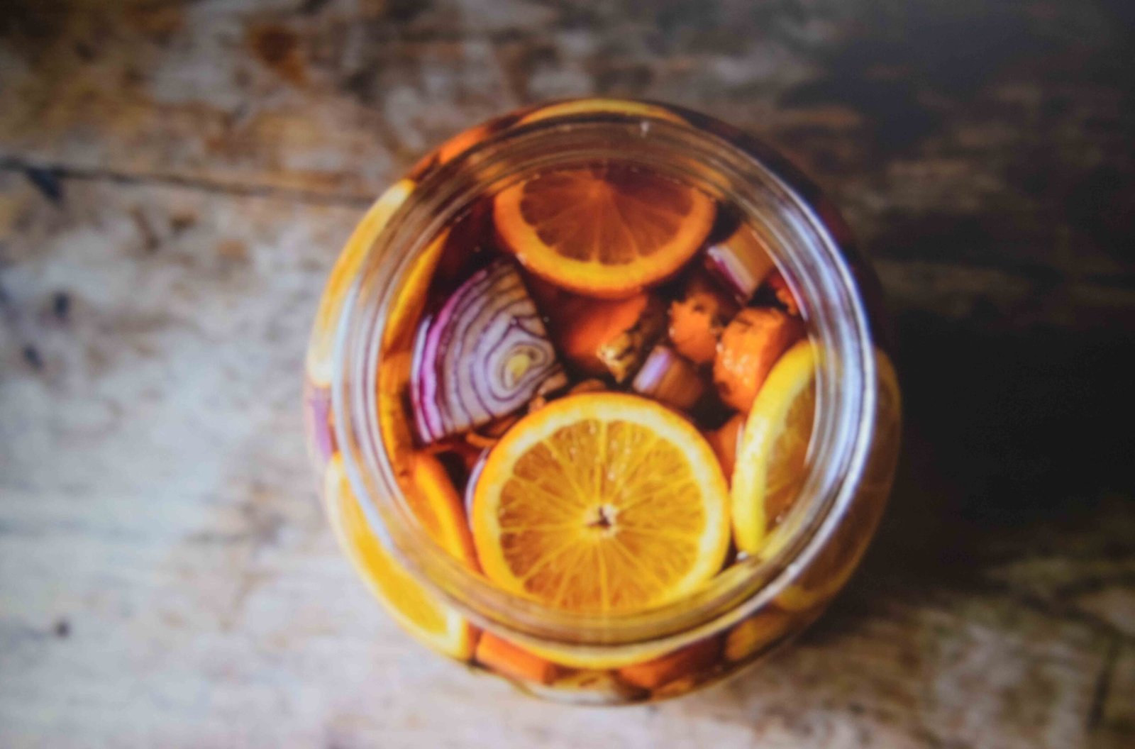 A packed half gallon jar showing a fire cider recipe steeping in apple cider vinegar