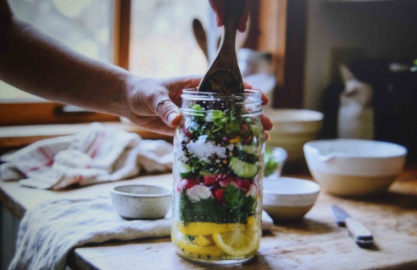 Layered ingredients pressed down into a glass jar for making fire cider