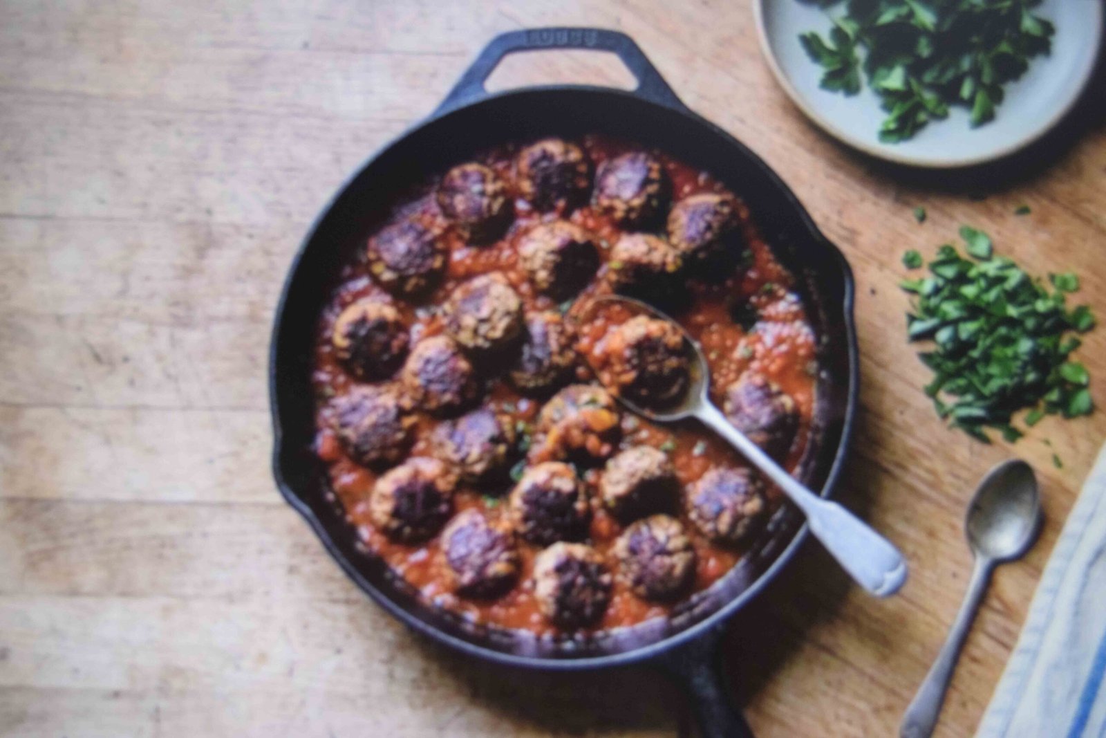 Browned meatballs returned to the sauce before parsley is added