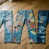 Three decorated denim pairs laid out showing different senior jeans ideas side by side