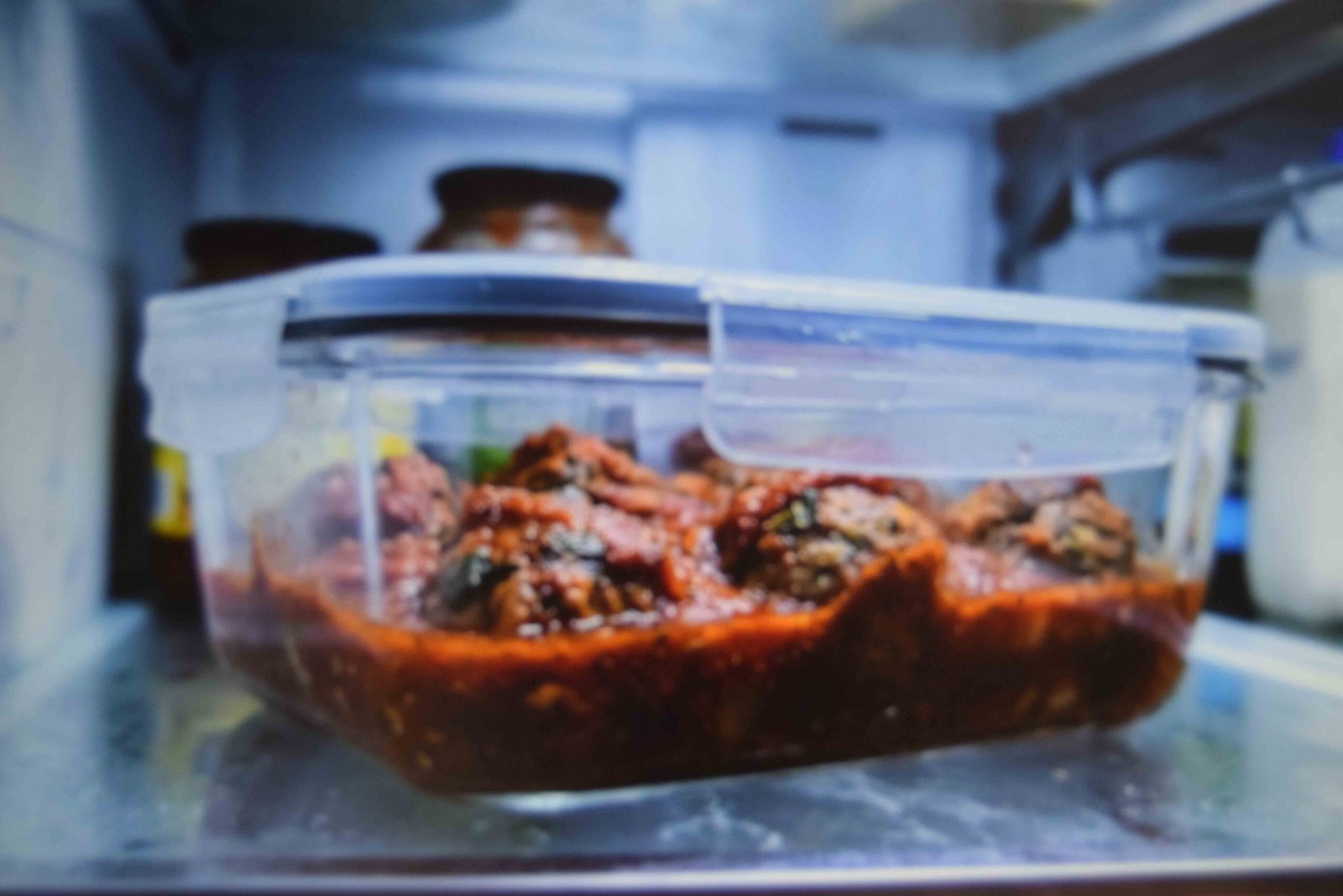 Leftover meatballs stored in their sauce in a sealed container