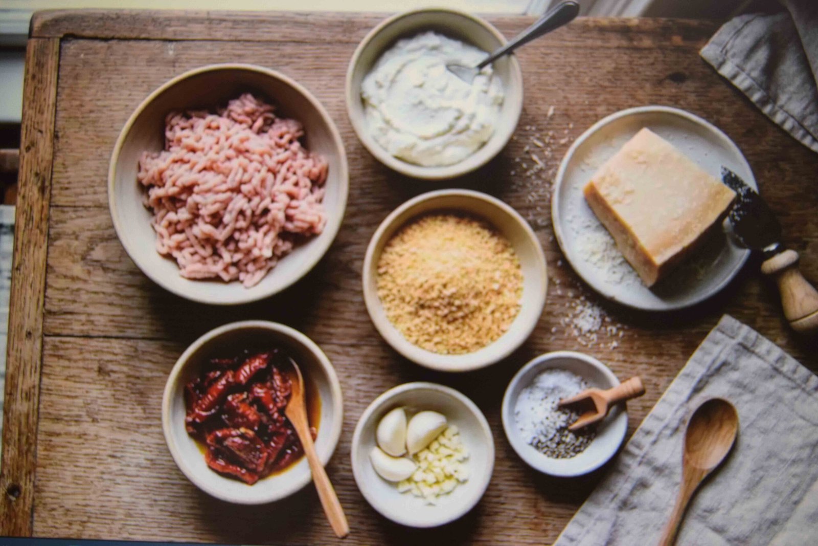 Measured ingredients laid out in bowls before making chicken meatballs